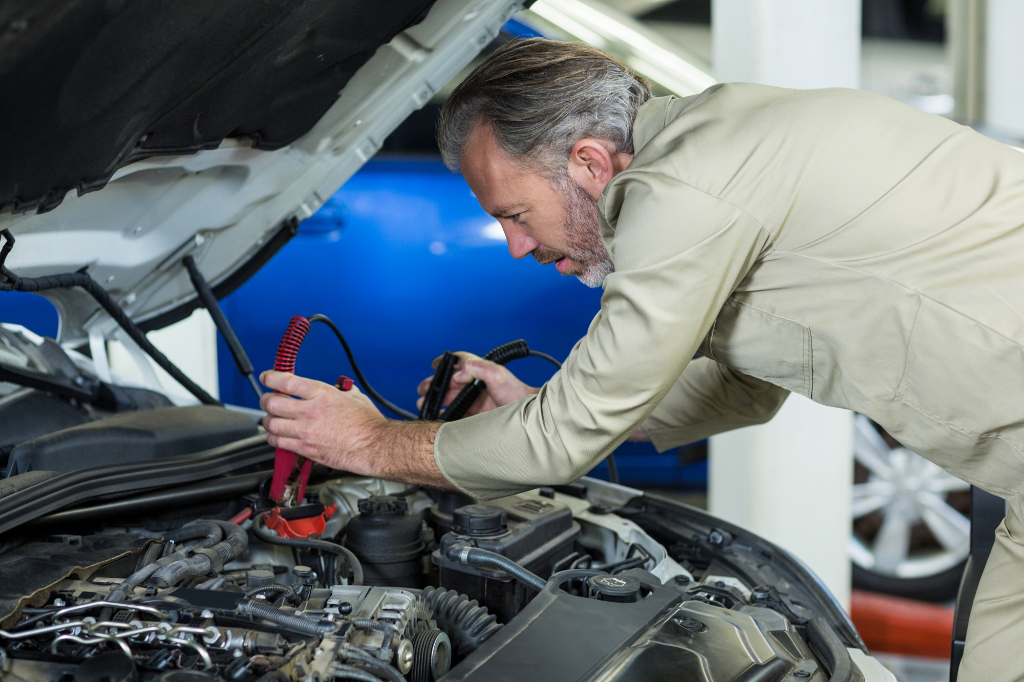 Mechanic inspecting engine using diagnostic tools
